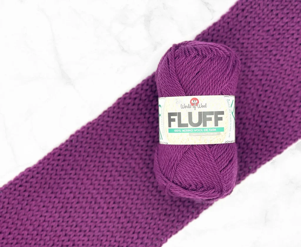 deep pink ball of wool with knitted piece behind